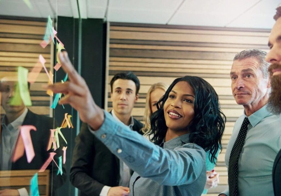 A woman pointing to the ceiling with paper stars hanging from it.